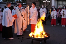  Am frisch entzündeten und geweihten Feuer wird die neue Osterkerze auf dem Kesselstädter Kirchplatz bei Einbruch der Dunkelheit entzündet